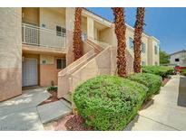 Charming condo exterior with landscaped walkway, stairs, and courtyard featuring mature palm trees at 5000 Red Rock St # 248, Las Vegas, NV 89118