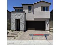 Contemporary two-story home featuring a stone facade, a two-car garage, and neat landscaping at 66 Via Montoro, Henderson, NV 89015