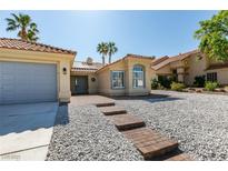 Charming home featuring desert landscaping, tile roof, and inviting double door entrance at 8150 Beaverbrook Way, Las Vegas, NV 89123