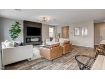 Stylish living room with a modern fireplace, hardwood floors, and bright, neutral decor at 9870 Fisher Bay Ct, Las Vegas, NV 89178