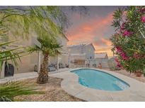 Inviting backyard pool with a desert landscape and relaxing lounge area, perfect for enjoying warm evenings at 1906 Desert Sage Ave, North Las Vegas, NV 89031
