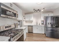 Modern kitchen features stainless steel appliances, gas range, white cabinets, and wood-look floors at 3417 Lillis Cir, North Las Vegas, NV 89030