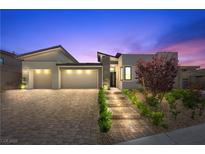 Stunning modern home with a three-car garage, beautiful landscaping, and a welcoming front entrance at 5166 Stone View Dr, Las Vegas, NV 89135