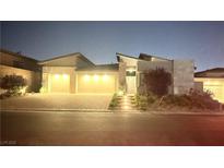 Charming single-story home featuring a three-car garage and beautifully illuminated at dusk at 5166 Stone View Dr, Las Vegas, NV 89135