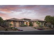 Stunning home showcasing a three-car garage, desert landscaping, and inviting curb appeal at dusk at 64 Tapadero Ln, Las Vegas, NV 89135