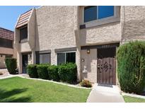 Charming townhome featuring a well-manicured lawn and beautiful desert landscaping at 6445 Ironbark Ln, Las Vegas, NV 89107