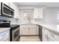 Bright kitchen featuring white cabinets, stainless steel appliances, and light countertops at 6871 Tamarus St # 204, Las Vegas, NV 89119