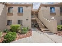 Inviting two-story condo building with well-kept landscaping, stairs and walkway to units at 7400 W Flamingo Rd # 1082, Las Vegas, NV 89147