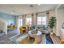 Bright living room showcasing modern furniture, large windows, and stylish decor with an adjacent dining area at 7915 Pandora Sky St # 402, North Las Vegas, NV 89084