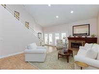 Bright living room features a fireplace, staircase, and double doors to the outside at 2749 Lodestone Dr, Las Vegas, NV 89117