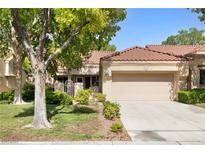 Charming single-story home featuring a two-car garage, tile roof, and mature trees enhancing the front yard at 2836 Linkview Dr, Las Vegas, NV 89134