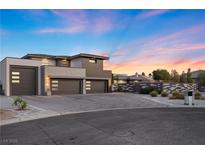 Modern home exterior with three-car garage, clean lines and desert landscaping at sunset at 4050 N Tomsik St, Las Vegas, NV 89129