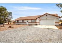 Charming single-story home with a tile roof, gravel yard, and attached two-car garage at 480 China St, Pahrump, NV 89048