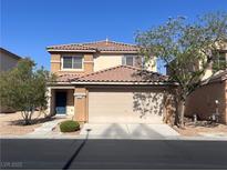 Two-story home featuring a tile roof, two car garage, and a tidy front yard with desert landscaping at 5477 Ovando Way, Las Vegas, NV 89122