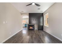 Bright living room features a fireplace with black accent wall and modern ceiling fan at 6260 Castle Kennedy St, Henderson, NV 89011