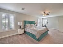 Spacious main bedroom featuring a green accent wall and bright, natural light from plantation shutters at 75 Archer Glen Ave, Henderson, NV 89002