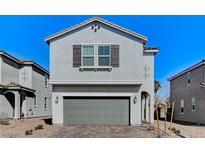 Charming two-story home with a gray exterior, a two-car garage, and a beautifully landscaped front yard at 8786 Sand Verbena Ave, Las Vegas, NV 89117