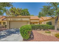 Inviting single-story home featuring a 2-car garage, lush landscaping, and charming curb appeal at 9024 Starmount Dr, Las Vegas, NV 89134