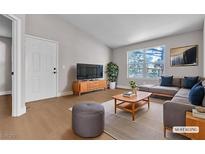 Cozy living room with a modern sofa, wooden floors, and view to the outside at 1150 N Buffalo Dr # 2025, Las Vegas, NV 89128