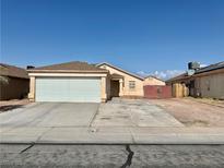 Single story home showcasing a large garage, a well-kept lawn, and a traditional desert landscape at 2621 Blue Reef Dr, North Las Vegas, NV 89032