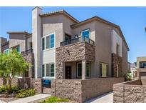 Attractive townhome featuring a stone facade, balcony, and a well-maintained front yard at 328 Owens Peak Dr, Henderson, NV 89015