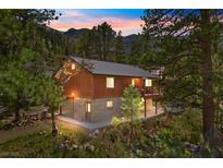 Stunning exterior view showcasing a charming two-story home nestled in a lush, wooded setting at 3971 Arlberg Way, Mount Charleston, NV 89124