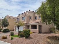 Inviting two-story home featuring well-maintained landscaping and a covered front porch at 412 Orchid Oasis Ave, North Las Vegas, NV 89031