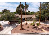 Inviting single-story home featuring mature trees and a circular driveway with desert landscaping at 4219 E Pinecrest Cir, Las Vegas, NV 89121