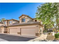 Attractive stucco townhome featuring a private two-car garage and a tile roof at 4725 Basilicata Ln # 204, North Las Vegas, NV 89084