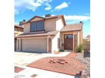 Charming two-story home featuring a tile roof, attached garage, and low maintenance front yard at 6529 Hartwood Rd, Las Vegas, NV 89108