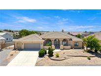 Beautiful one-story home featuring arched entry, desert landscaping, and an attached two-car garage at 6841 Longmeadow Dr, Pahrump, NV 89061
