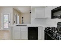Modern kitchen featuring white cabinets, countertops, and black appliances at 9050 W Warm Springs Rd # 1117, Las Vegas, NV 89148