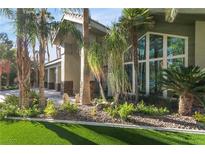 Stunning home exterior featuring lush landscaping and a modern architectural design with large windows at 2309 Prometheus Ct, Henderson, NV 89074