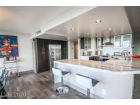 Modern kitchen featuring stainless steel appliances and marble countertops and sleek gray and white cabinetry at 3111 Bel Air Dr # 4B, Las Vegas, NV 89109