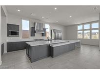 Bright kitchen boasts a large island, stainless steel appliances, modern cabinets, and views of the backyard at 5364 Succulent Rose Dr, Las Vegas, NV 89135