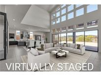 Bright, virtually staged living room with high ceilings, large windows, and open floor plan to kitchen at 5364 Succulent Rose Dr, Las Vegas, NV 89135