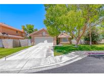Charming single-story home with a well-manicured lawn, mature tree, and attached two-car garage at 5639 Guiding Star Cir, North Las Vegas, NV 89031