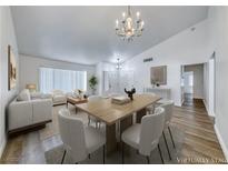 Bright living room with modern decor, wood floors, dining table, and large windows at 5639 Guiding Star Cir, North Las Vegas, NV 89031