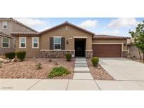 Charming single-story home featuring a stone veneer, desert landscaping, and a two-car garage at 705 Coastal Lagoon St, Henderson, NV 89002