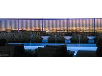 Resort-style pool with water features and comfortable lounge seating overlooking a vibrant city skyline at dusk at 826 Bolide St, Las Vegas, NV 89138