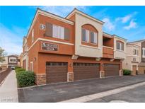 Attractive condo building featuring multiple units and attached garages with stone accents on the facade at 9303 Gilcrease Ave # 1013, Las Vegas, NV 89149