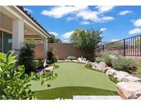 Landscaped backyard featuring a putting green, desert plants, and privacy fence at 10416 Skye Arroyo Ave, Las Vegas, NV 89166