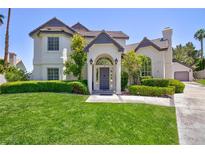 Charming two-story home featuring a lush green lawn and well-maintained landscaping in a suburban setting at 15 Pheasant Ridge Dr, Henderson, NV 89014