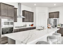Modern kitchen featuring gray cabinets, stainless steel appliances, and an island with marble countertops at 1596 Pacific Baza St, Las Vegas, NV 89138