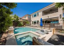 Backyard pool and hot tub, surrounded by lush greenery and comfortable lounge area for relaxation and outdoor entertainment at 2750 Evolutionary Ln, Las Vegas, NV 89138