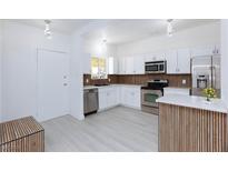 Bright kitchen featuring stainless steel appliances, white cabinetry, and modern lighting fixtures at 3008 Lawndale St, Las Vegas, NV 89121