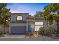Two-story home featuring a xeriscaped front yard, tile roof, and attached two-car garage at 3481 Creek River Dr, Las Vegas, NV 89129