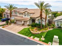 Beautiful two-story home with a well-manicured front yard, palm trees, and a three-car garage at 4326 Spooner Lake Cir, Las Vegas, NV 89147