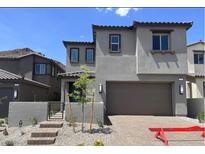 Two-story home featuring a two-car garage, gray stucco, and a landscaped front yard with steps leading to the entry at 72 Via Montoro, Henderson, NV 89011