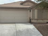 Single-story home with a two-car garage, neutral paint, and desert landscaping at 7850 Flagler St, Las Vegas, NV 89139